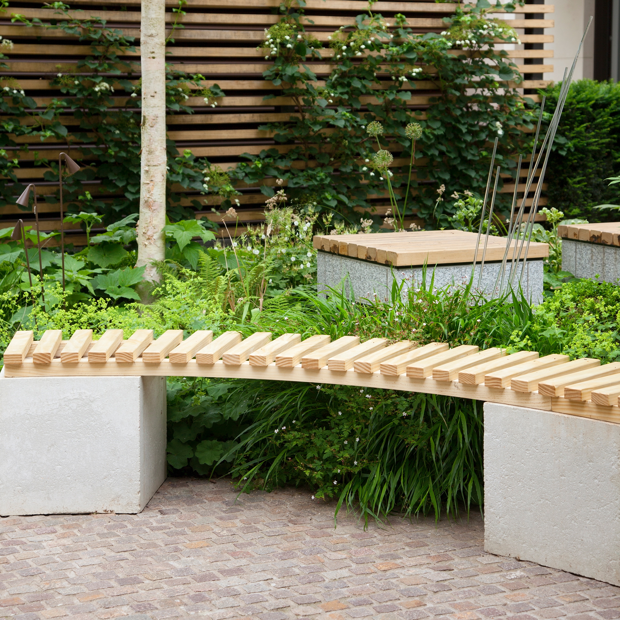 Curved bespoke garden bench with concrete base and slatted seat