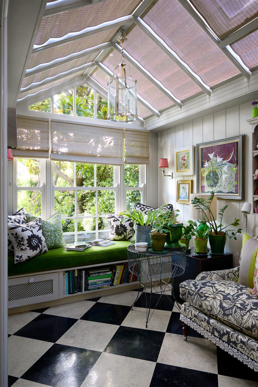 Cozy sunroom filled with plants and comfortable seating.