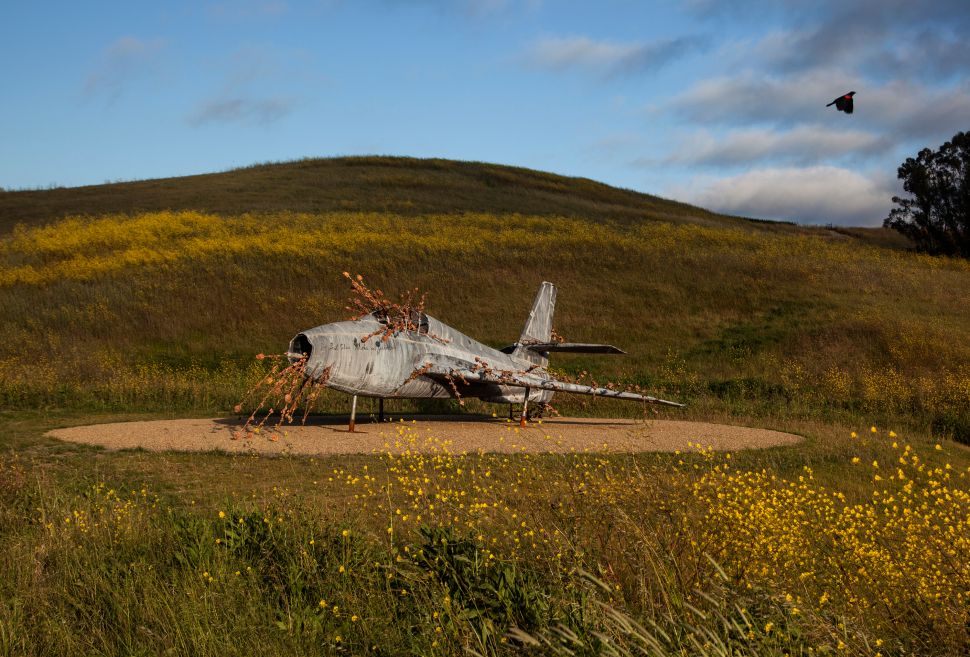 Anselm Kiefer’s weathered airplane sculpture rests on a gravel platform amid wildflowers and rolling hills at The Donum Estate.