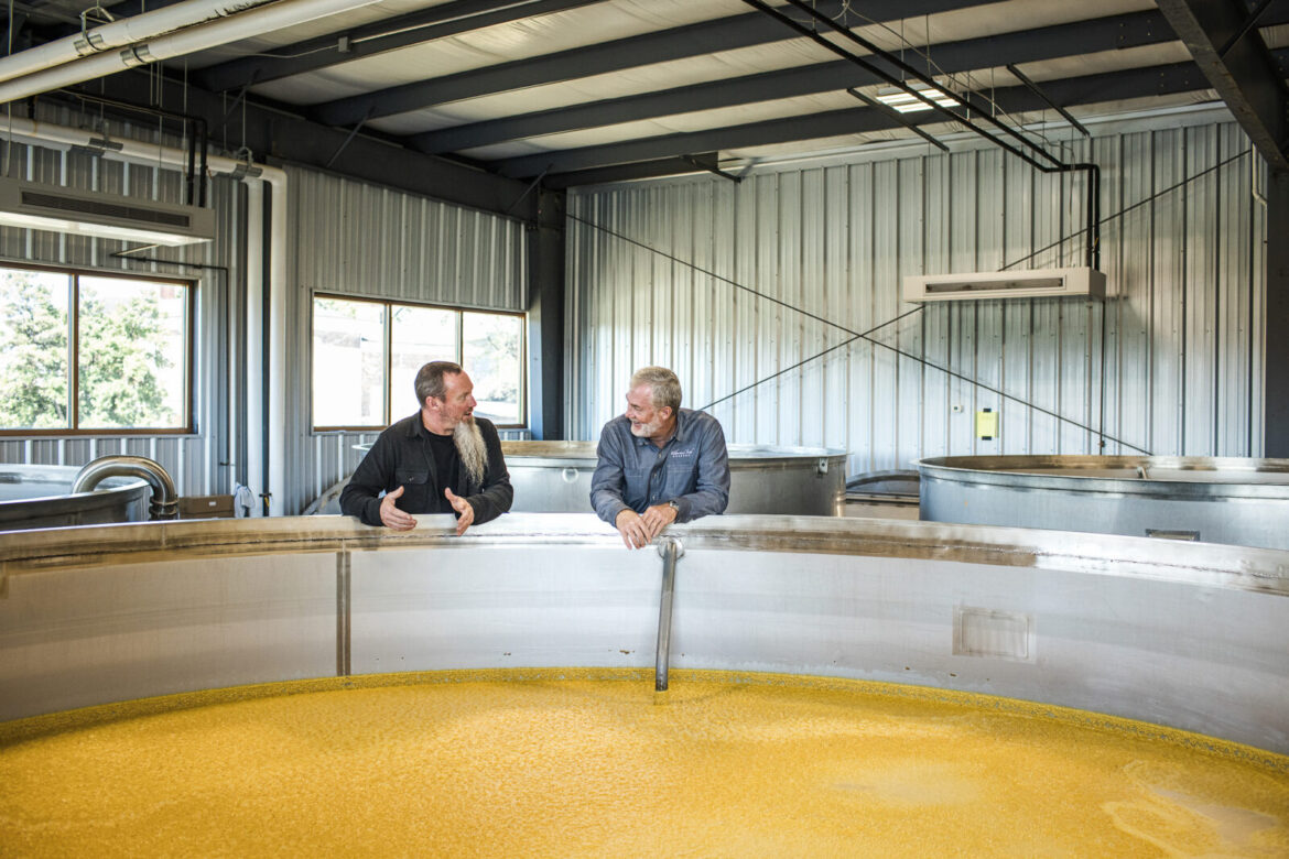 The Cult of Sweet-Mash Whiskey – Garden & Gun Two men stand over a distilling tank