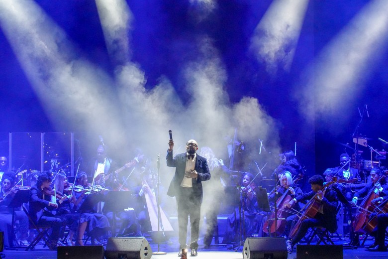 Arly Larivière raises his microphone during his performance at the Infosys Theatre in Madison Square Garden on Saturday, February 14, 2026, in Manhattan. Photo by Fredner Cayemitte / The Haitian Times.
