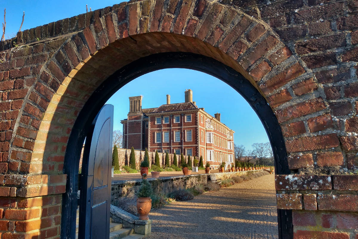 A view of Ham House through a brick archway