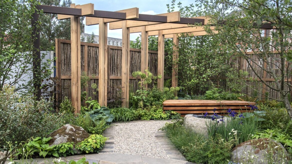 Easy Plants to Propagate in February From Hardwood Cuttings A large wooden pergola sits atop a garden filled with green borders and a gravel path