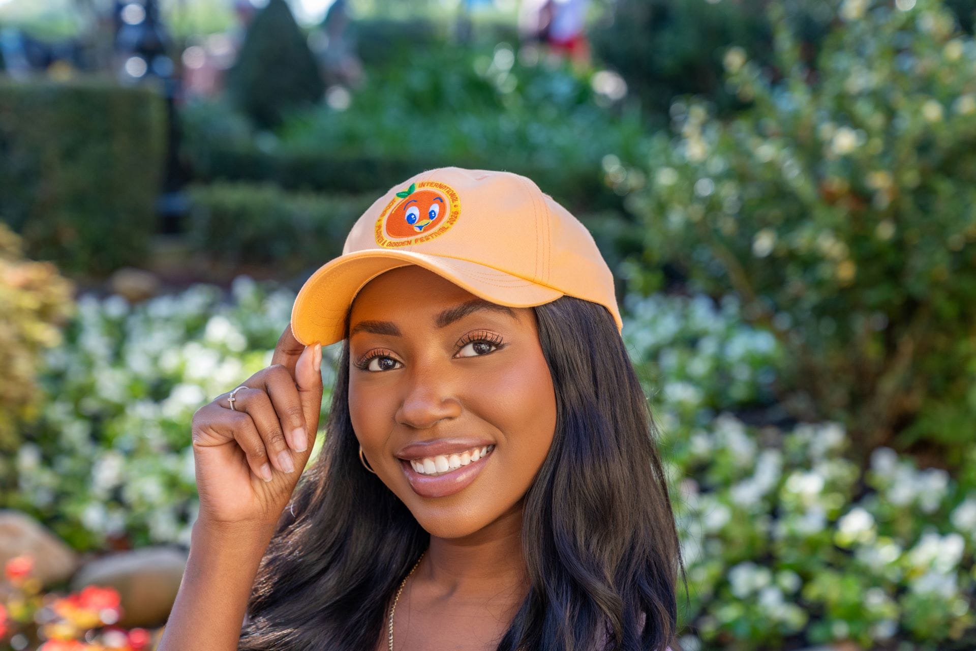 The final merchandise item in this preview is a light orange Orange Bird hat. It shows an embroidered Orange Bird face on the front surrounded by a circular 