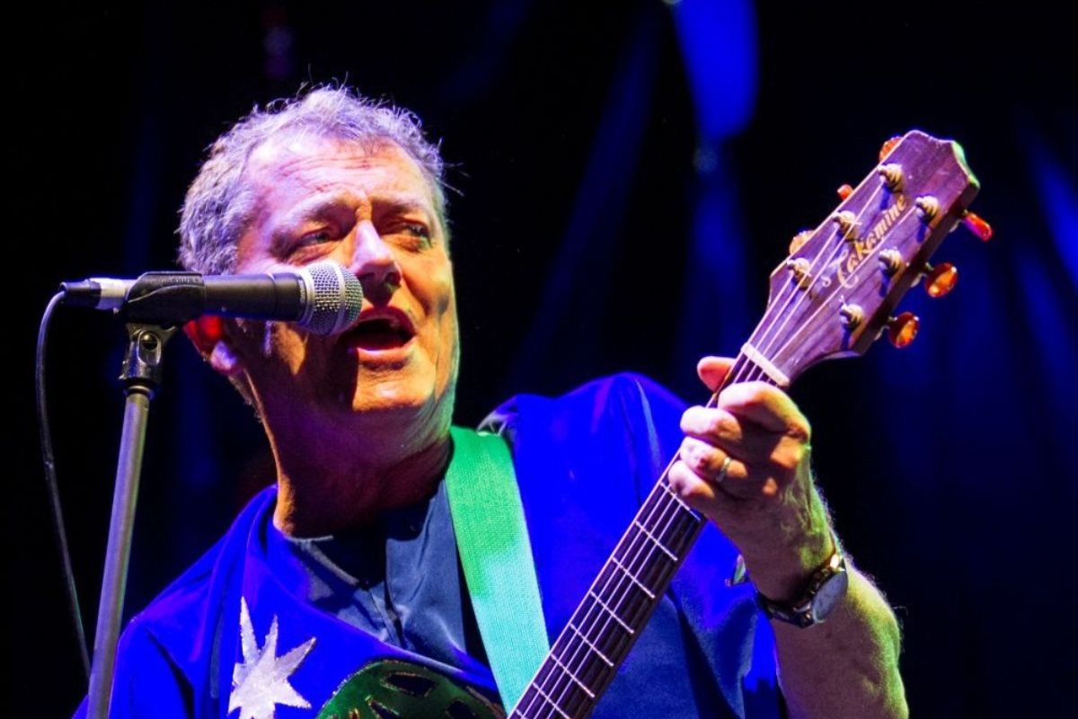 Peter Combe performance playing guitar and singing.