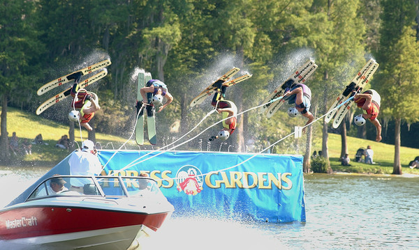 Five skiers complete a jump and forward somersault in the...