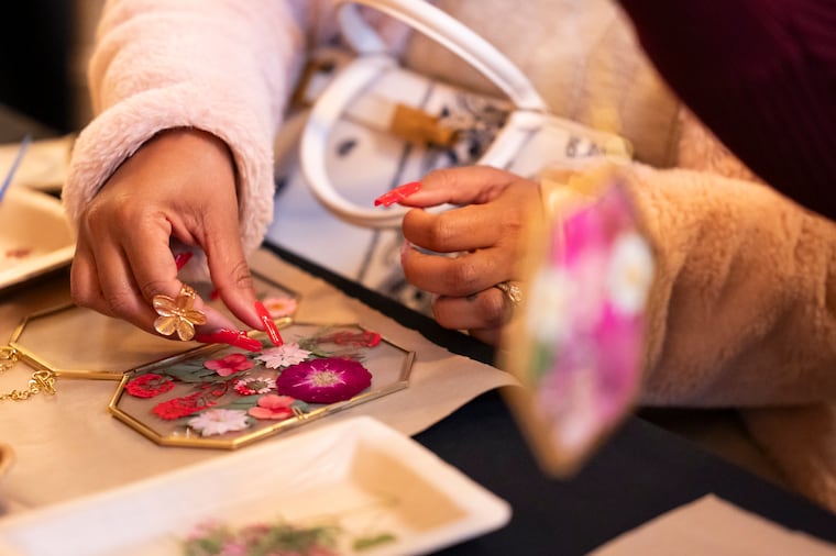 A participant creates pressed flower art following a Jan. 14 news conference at Union Trust for the unveiling of a first look at the 2026 Philadelphia Flower Show, "Rooted: Origins of American Gardening."