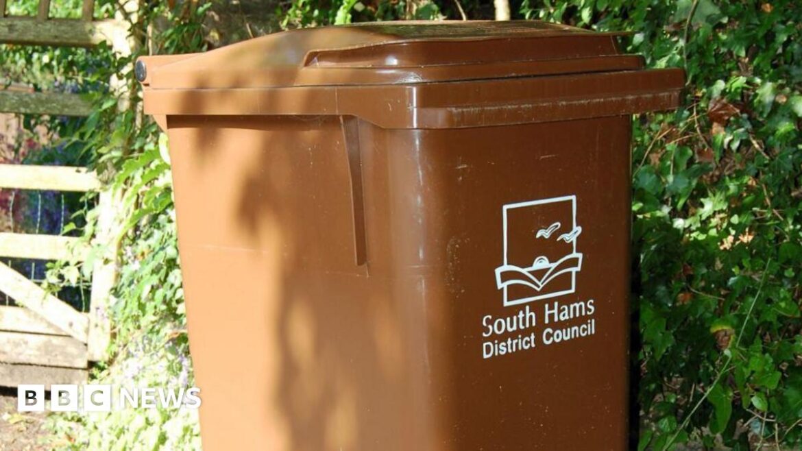 South Hams residents can sign up for garden waste collections A brown wheelie bin with the words 'South Hams District Council' printed on the front in white writing, with an image of a sunset and birds.