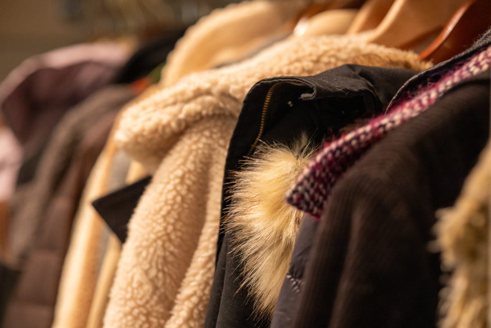 row of coats (some vintage) hanging in coat closet in residential home