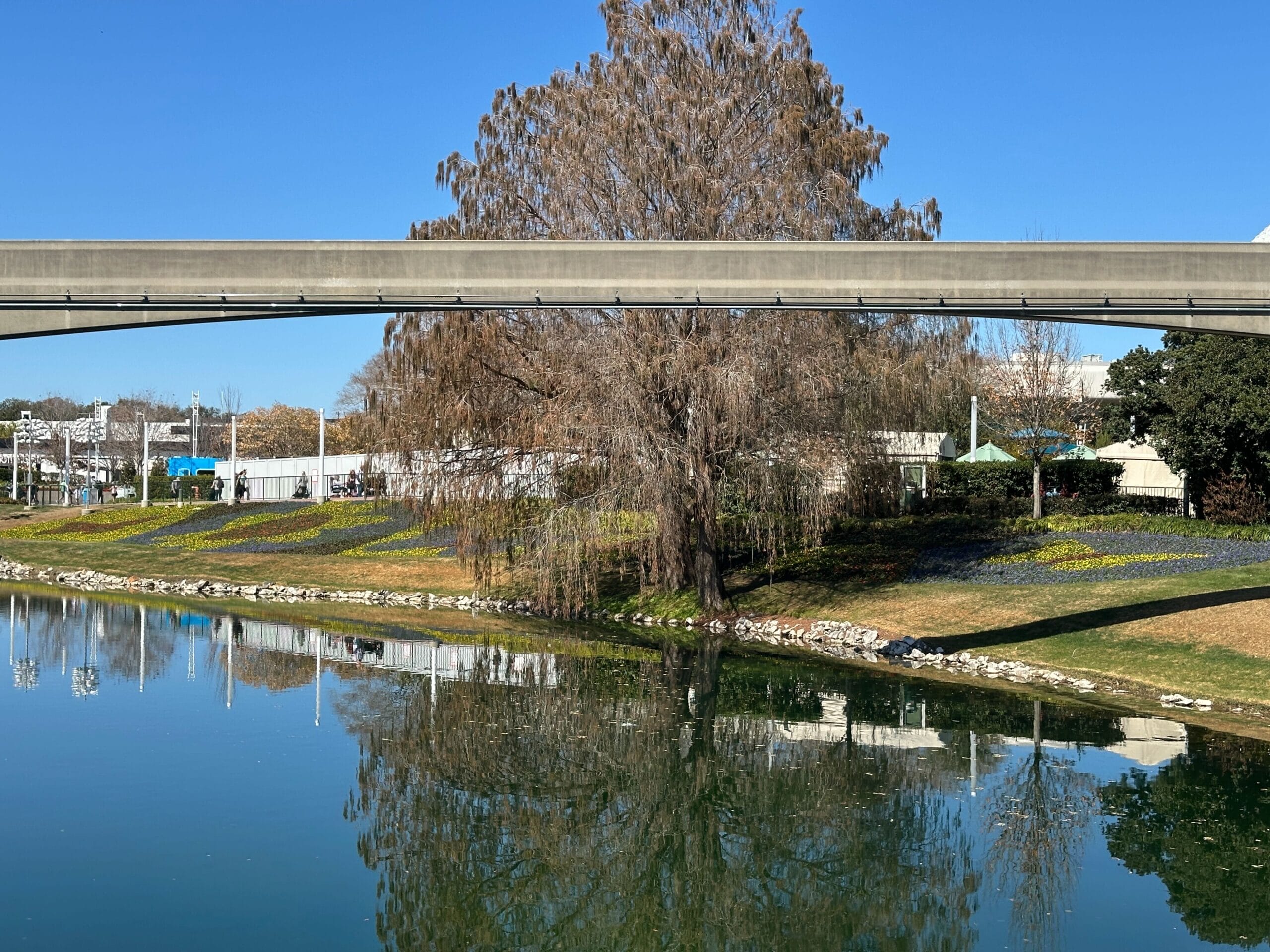 On the other side of the pond, we see even more butterfly and flower images made up of plants. These are shaded slightly by the tree beside the water.