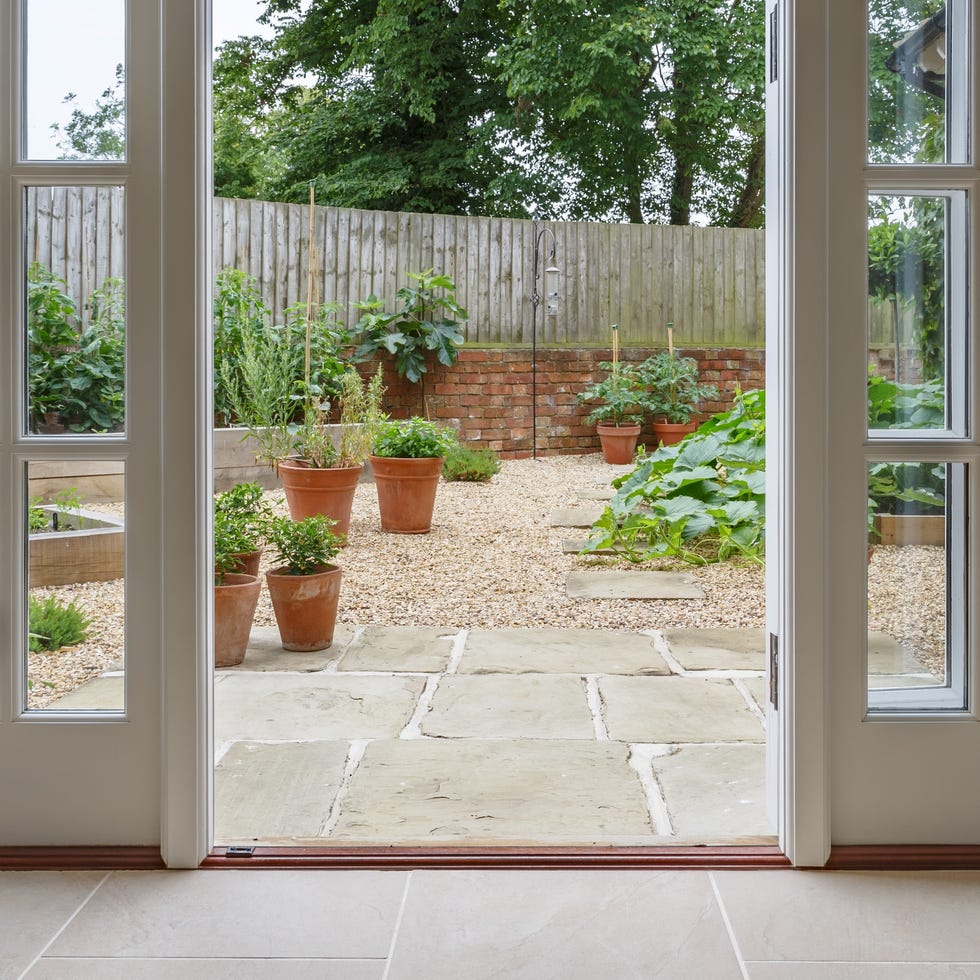 view of garden from inside house with french doors leading to a courtyard kitchen garden
