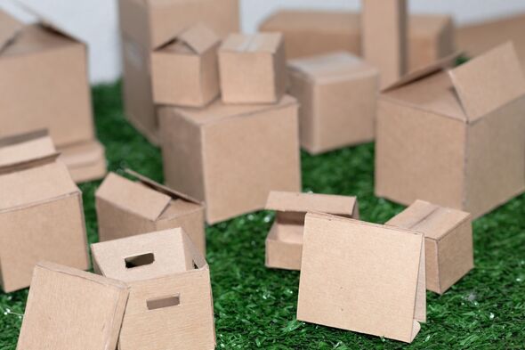 Mini recycled cardboard boxes grouped on green artificial grass Mini recycled cardboard boxes grouped on green artificial grass