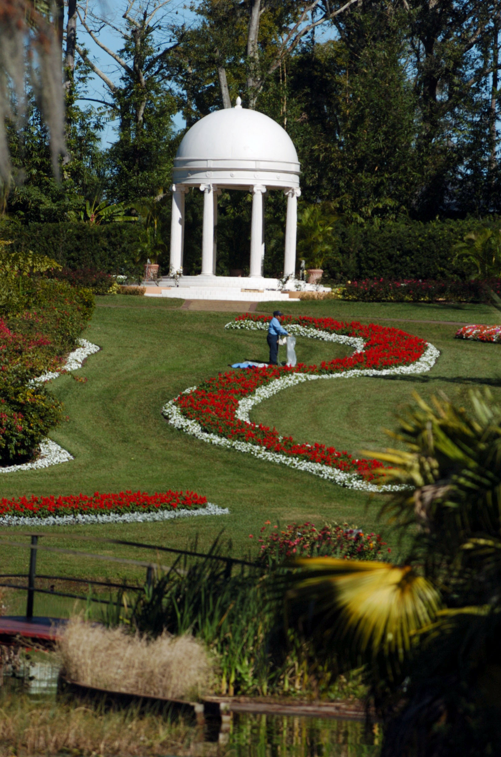 A Cypress Gardens employee checks the flowers around the gazebo...