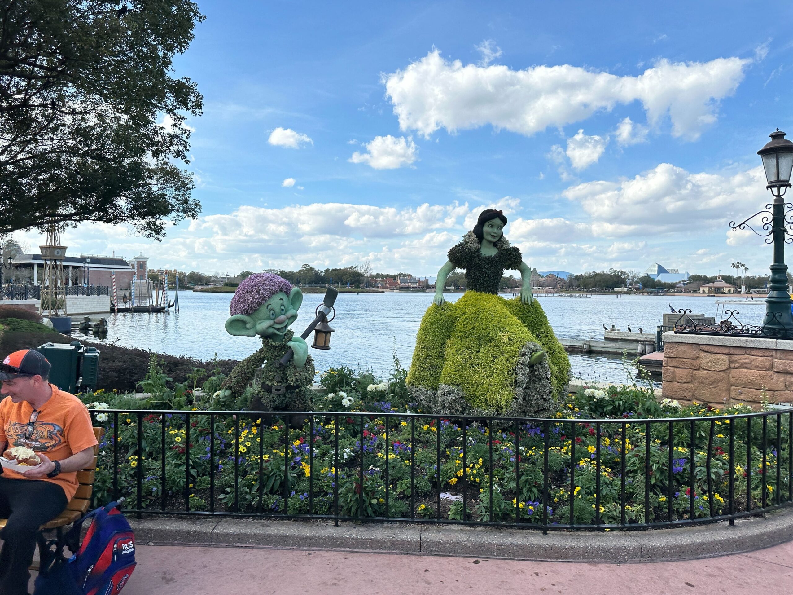 Snow White and Dopey are in a flowerbed next to the Friendship Boat dock at the Germany pavilion