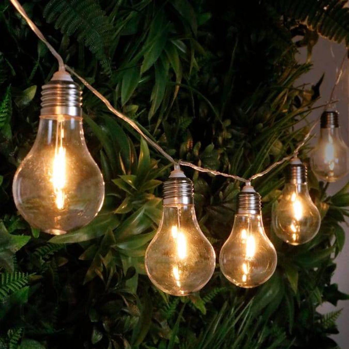 The Plastic Bulb String Party Lights cast a warm white glow onto gardens