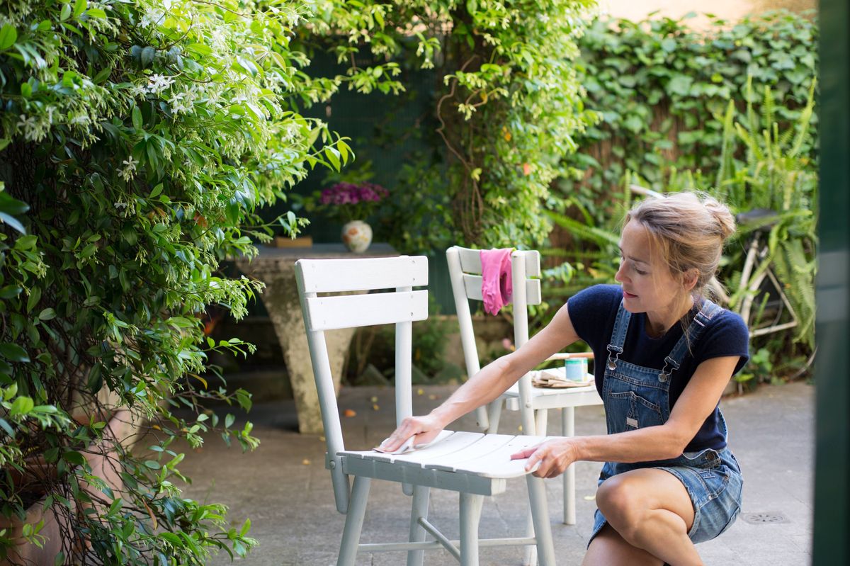 DIY: Woman sanding wooden chairs