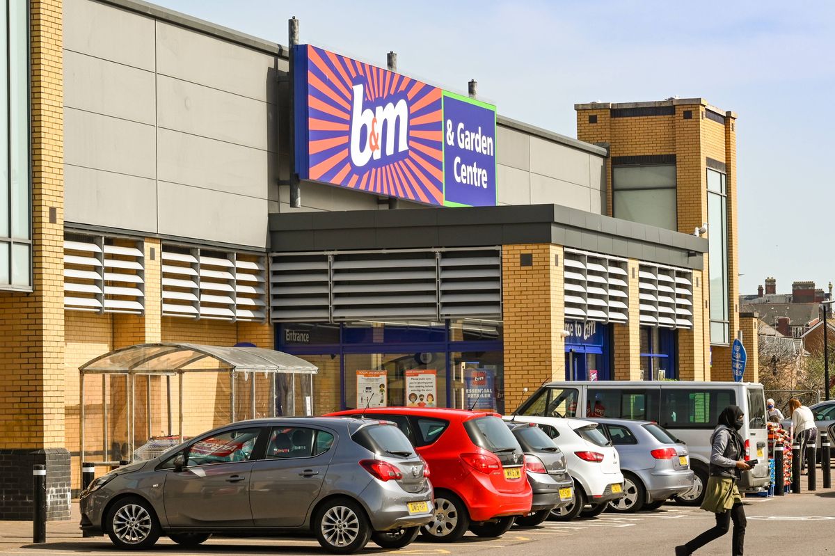 Barry, Wales - March 2021: Exterior view of the entrance to a branch of B&M Home Bargains in a retail park, with cars parked outside.
