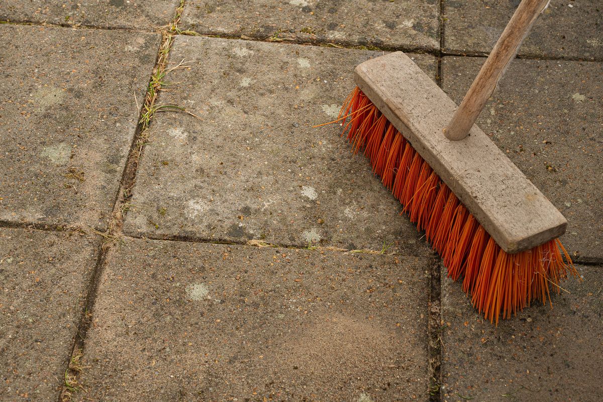 Broom standing on freshly washed garden tiles