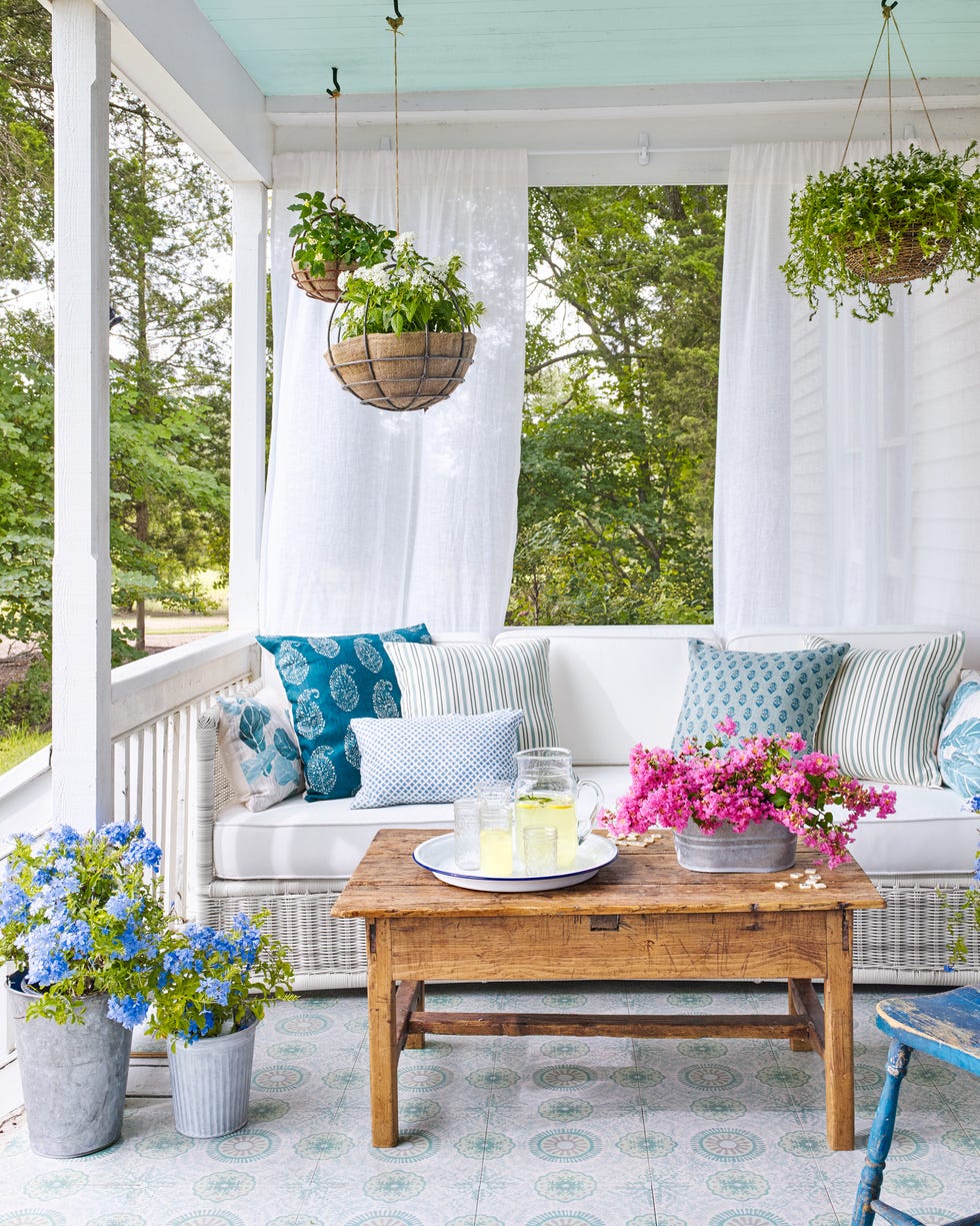 front porch with white wicker couch and curtains hanging behind it front porch with white wicker couch and curtains hanging behind it