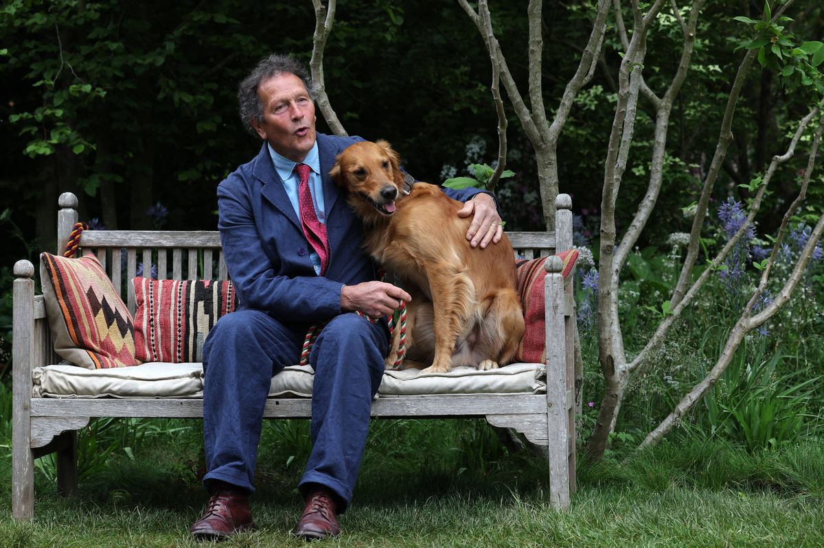 Gardener Monty Don poses with his dog Ned, a Golden Retriever, in his dog-friendly garden, during the preview day at the RHS Chelsea Flower show, in London, on May 19, 2025. Sweet potatoes sprouting among flowers, talking trees powered by AI and drought resistant crops, the prestigious Chelsea Flower Show is facing the future focusing on innovation and climate change adaptation. (Photo by Adrian Dennis / AFP) (Photo by ADRIAN DENNIS/AFP via Getty Images)
