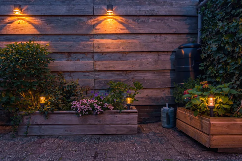 solar powered outdoor lighting illuminating a garden with flowers and plants.