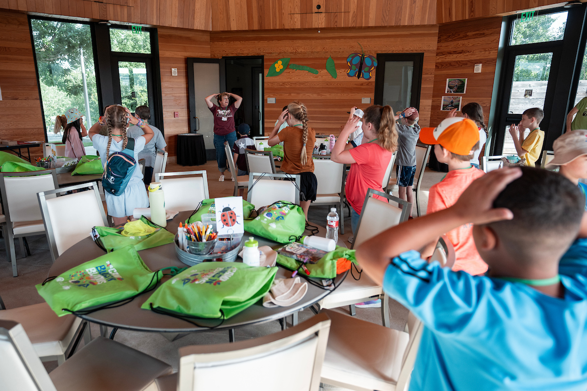 Lisa Whittlesey in the background directs a class of kids during a Bugs N Blooms event. 
