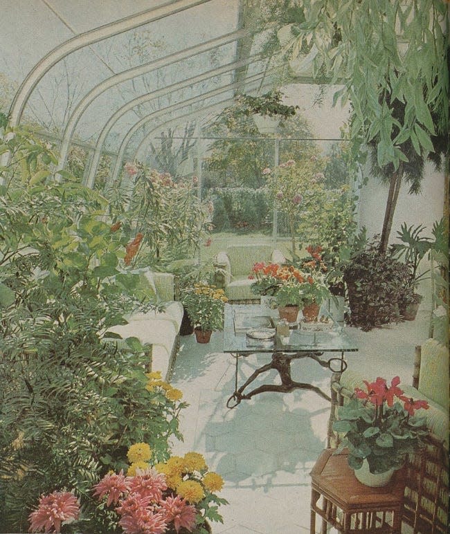 a glassenclosed garden space filled with various plants and seating