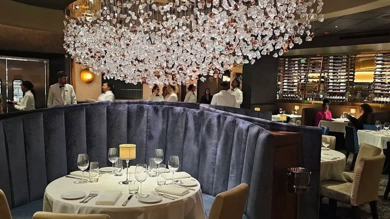 Eddie V's restaurant interior showing booth and large chandelier.