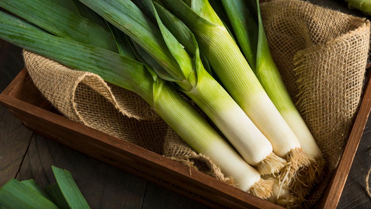 freshly picked leeks in a wooden box.