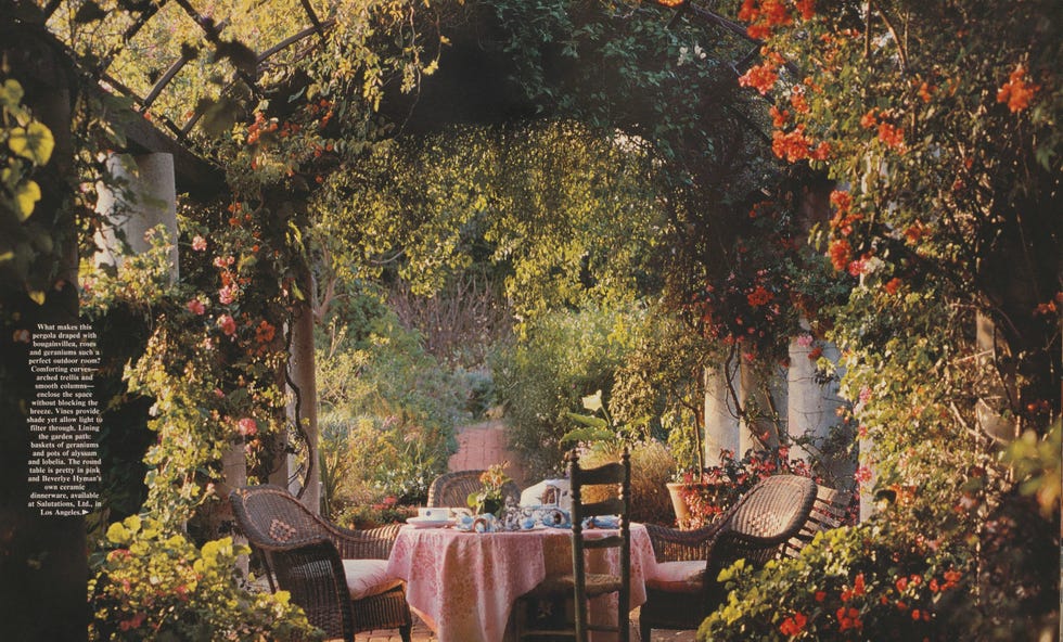 outdoor garden dining area with a table set under a floral pergola