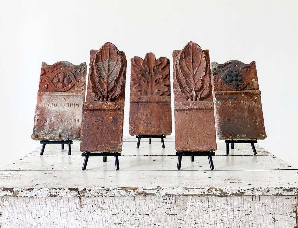 Set of antique decorative tiles displayed on a table.