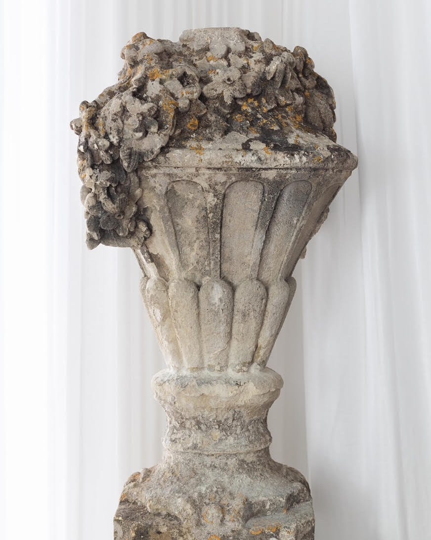 Decorative stone urn with floral motifs.