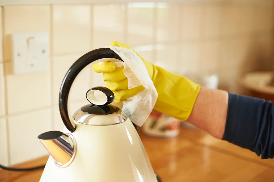 A woman wipes down her kettle.
