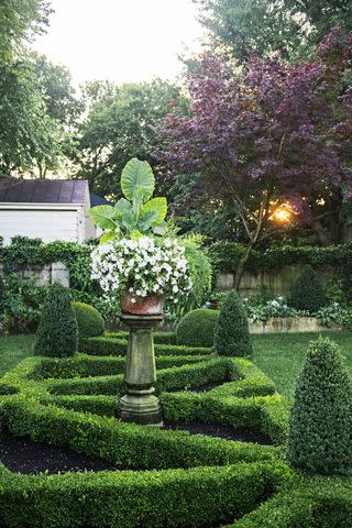 A combination of low-growing boxwood hedges, conical columns, and shapely globes gives garden designer Jon Carloftis’ Kentucky yard its traditional look.Credit: Gabriela Herman