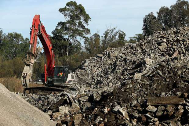 An excavator operator sorts strands of metal rebar out of a pile of concrete at the Stony Point Rock Quarry in Cotati, California on Thursday, November 30, 2017. Structural concrete removed by the Army Corps of Engineers from sites destroyed by the wildfires are brought to Stony Point Rock Quarry for recycling. (Alvin Jornada / The Press Democrat)