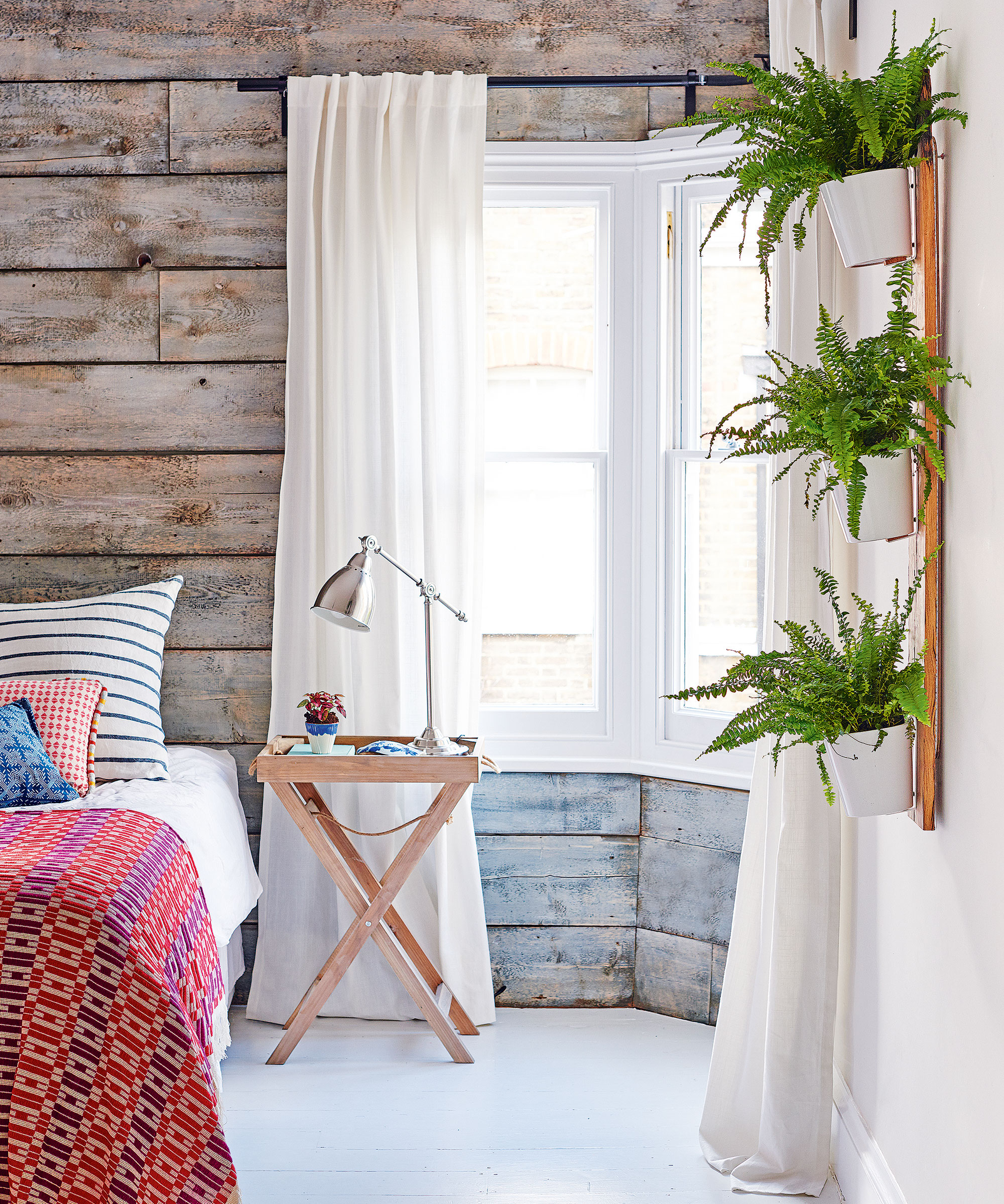 Bedroom with wood panels and house plants