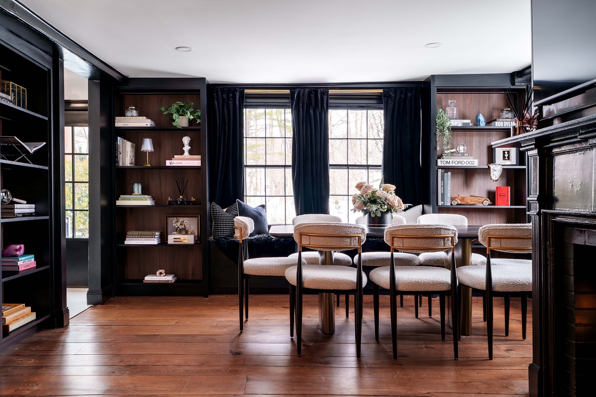 black walls and shelving behind cream upholstered chairs