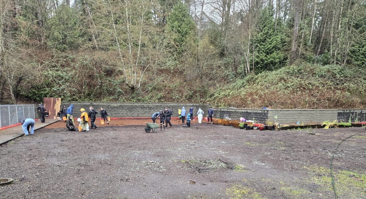 Workers work the soil in the garden