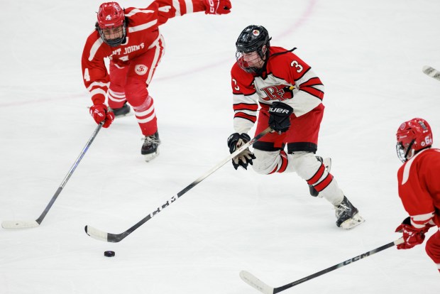 Pope Francis' Jack Allen splits between two St John's players as he takes the puck up the ice in the Division 1 boys hockey state title game at TD Garden. (Jake Whiting/Boston Herald)