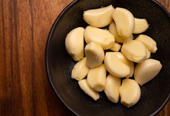 Peeled Garlic Bulbs in Rustic Bowl on Kitchen Counter