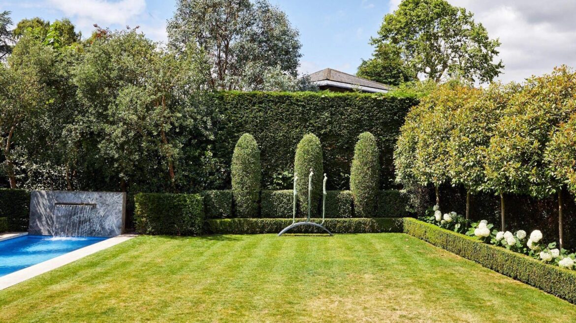 What to Do With a Lawn in March for a Lush, Green, Picture-Perfect Lawn A manicured lawn with shrubs, trees, and a backyard pool