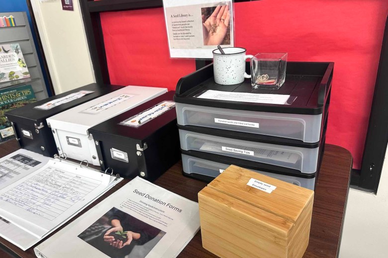 Boxes of seeds and a signin page sit on a desk