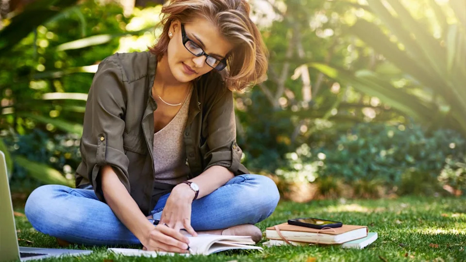 Woman, writing and relax in garden with notebook for fresh air while journal and remote work outdoor