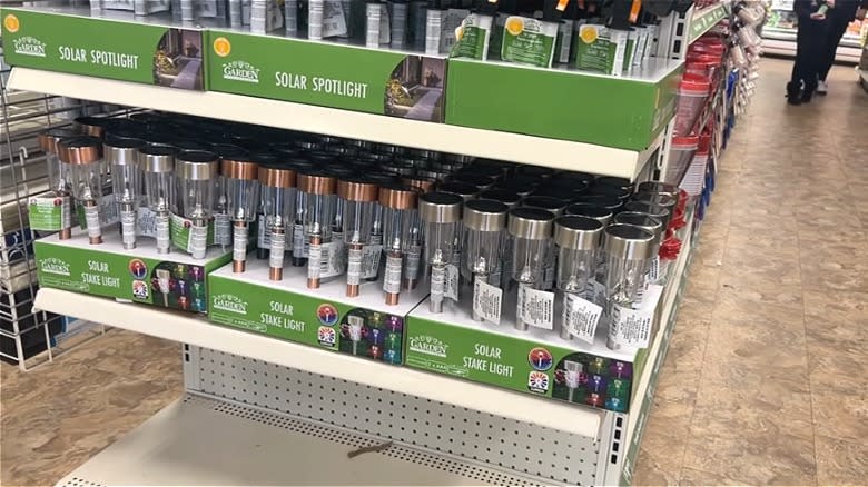 Solar stake lights organized on a Dollar Tree shelf.