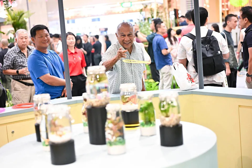 Community in Bloom ambassador Siva Rajoo, 84, playing the kid-friendly carnival hoopla game, as part of the Singapore Garden Festival 2026 launch event at Takashimaya Square on March 12.
