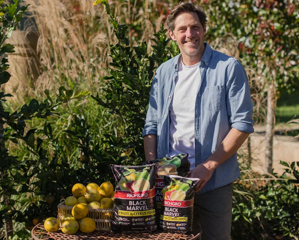 Horticulturist and landscaper Charlie Albone outdoors with a range of RichGro gardening products.