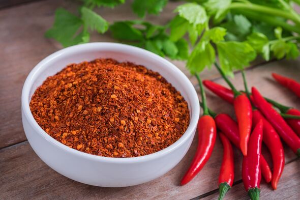 Chili cayenne in bowl and fresh chili on wooden table Chili cayenne in bowl and fresh chili on wooden table