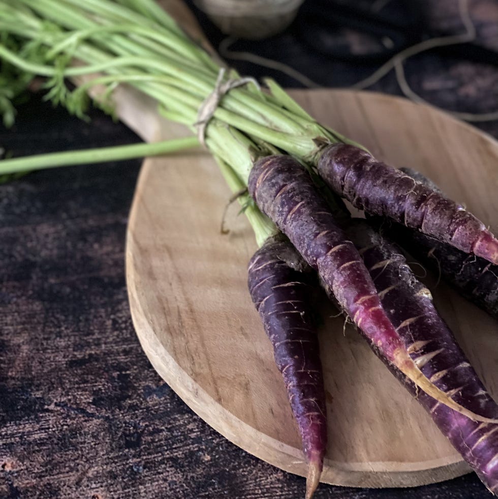 still life background with purple carrots on a chopping board still life background with purple carrots on a chopping board