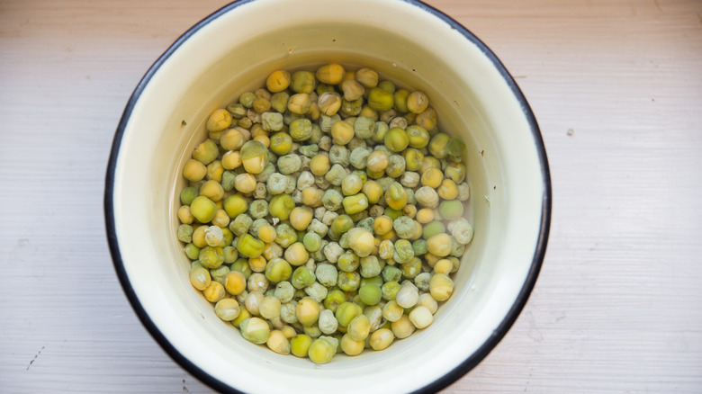 a bowl of pea seeds soaked in water for planting