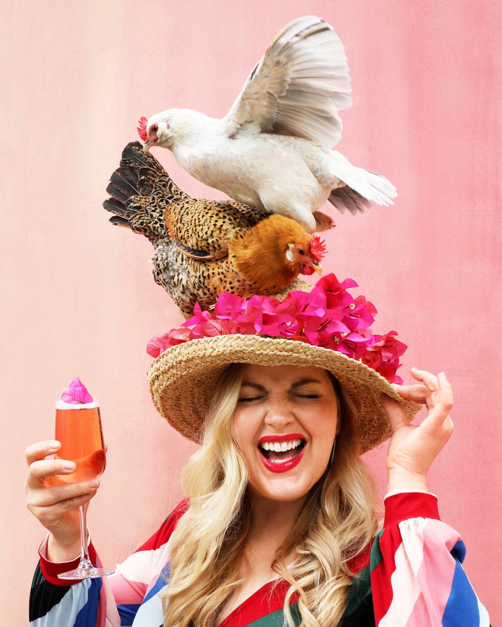Kate Richards with Her Chickens kate richards with a cocktail and a chicken landing on her sun hat